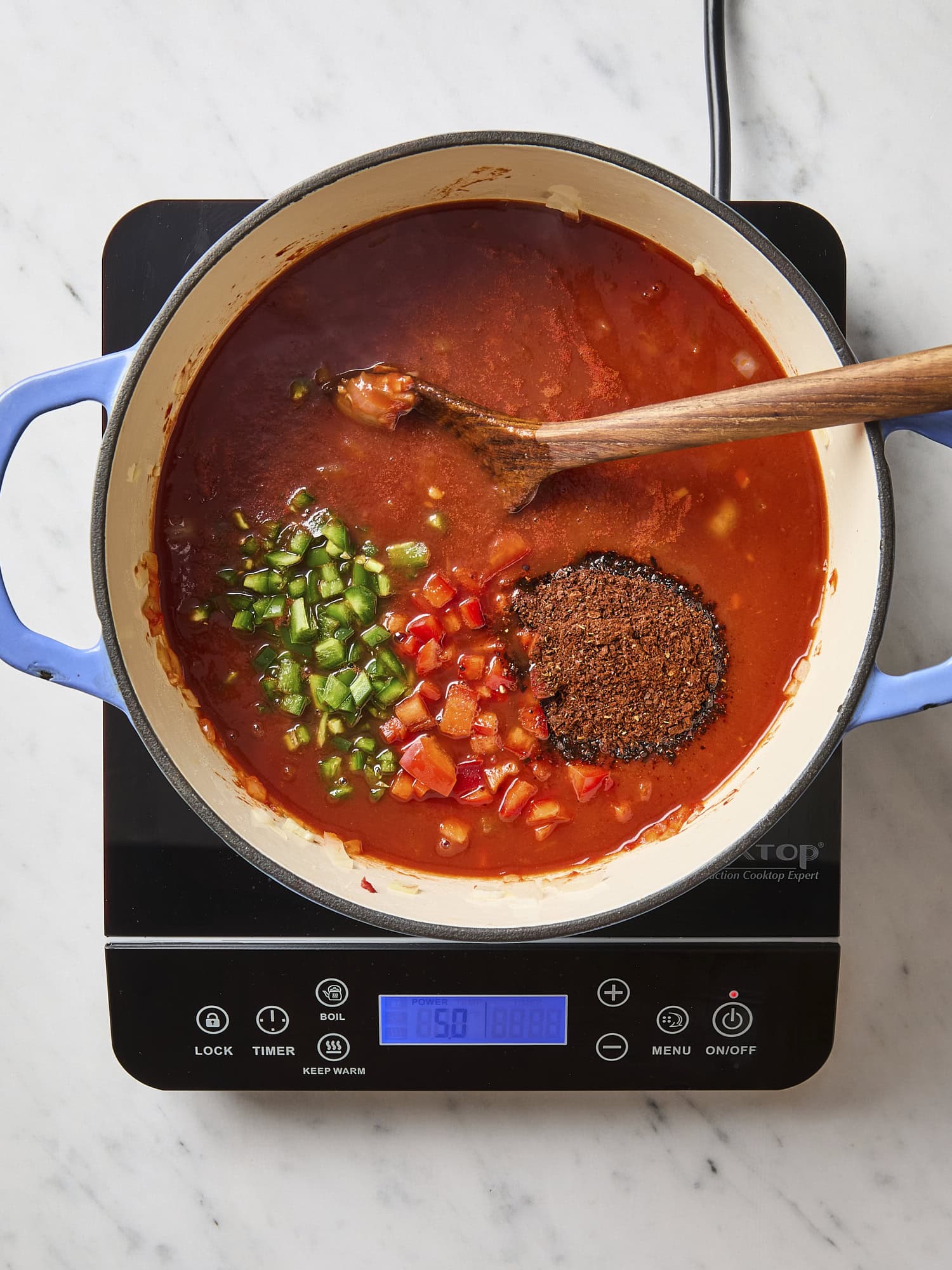 Spices and veggies being added to chili recipe.
