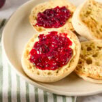 Blackberry jam spread on a muffin with butter.