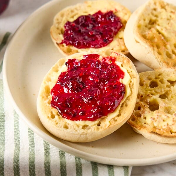 Blackberry jam spread on a muffin with butter.