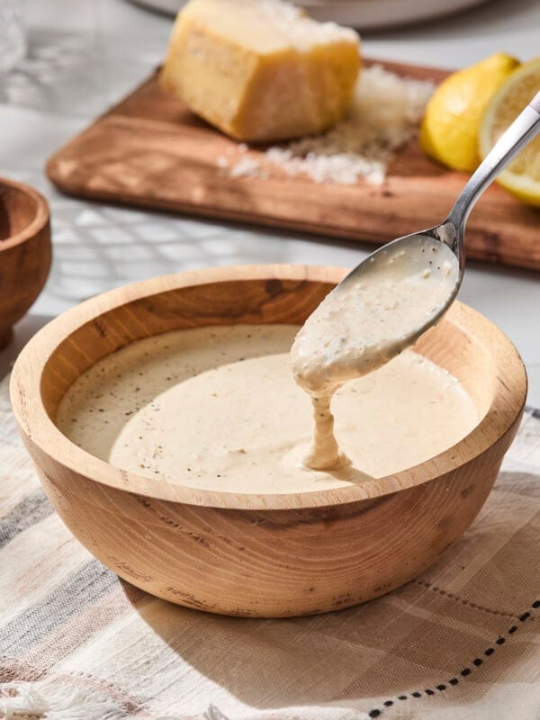 Small bowl with spoon showing Caesar dressing texture.