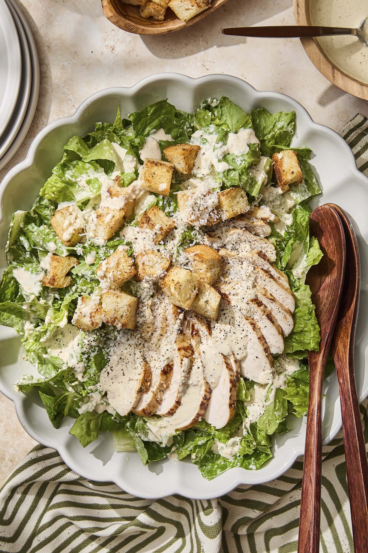 Chicken Caesar salad with croutons and dressing on top in bowl.