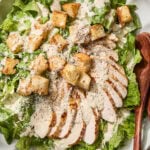 Chicken Caesar salad with sliced chicken, croutons, and dressing.