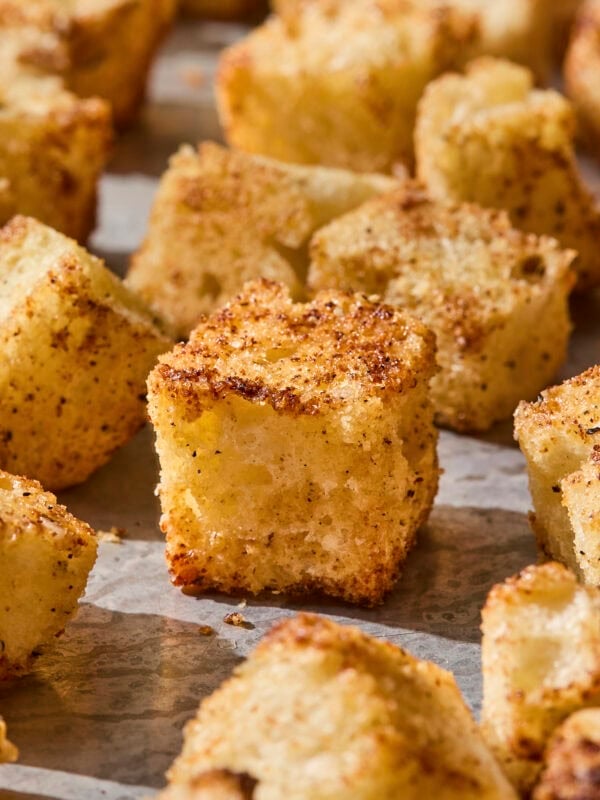 Baked crispy and golden homemade croutons on a sheet pan.