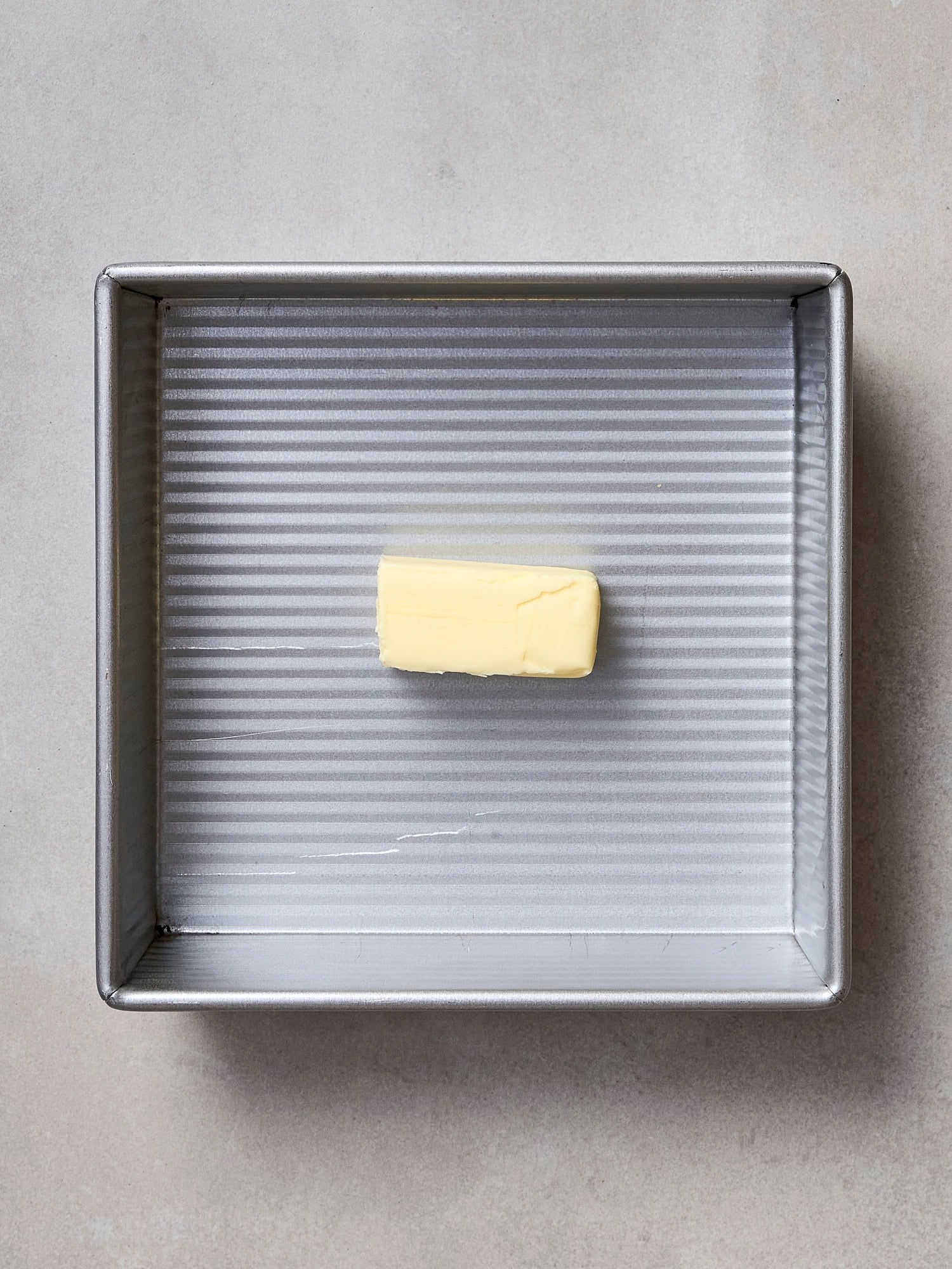 Unmelted stick of butter in a baking dish.