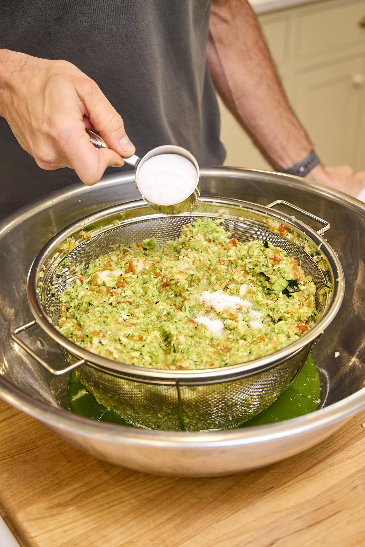 Adding salt to chopped zucchini mixture.