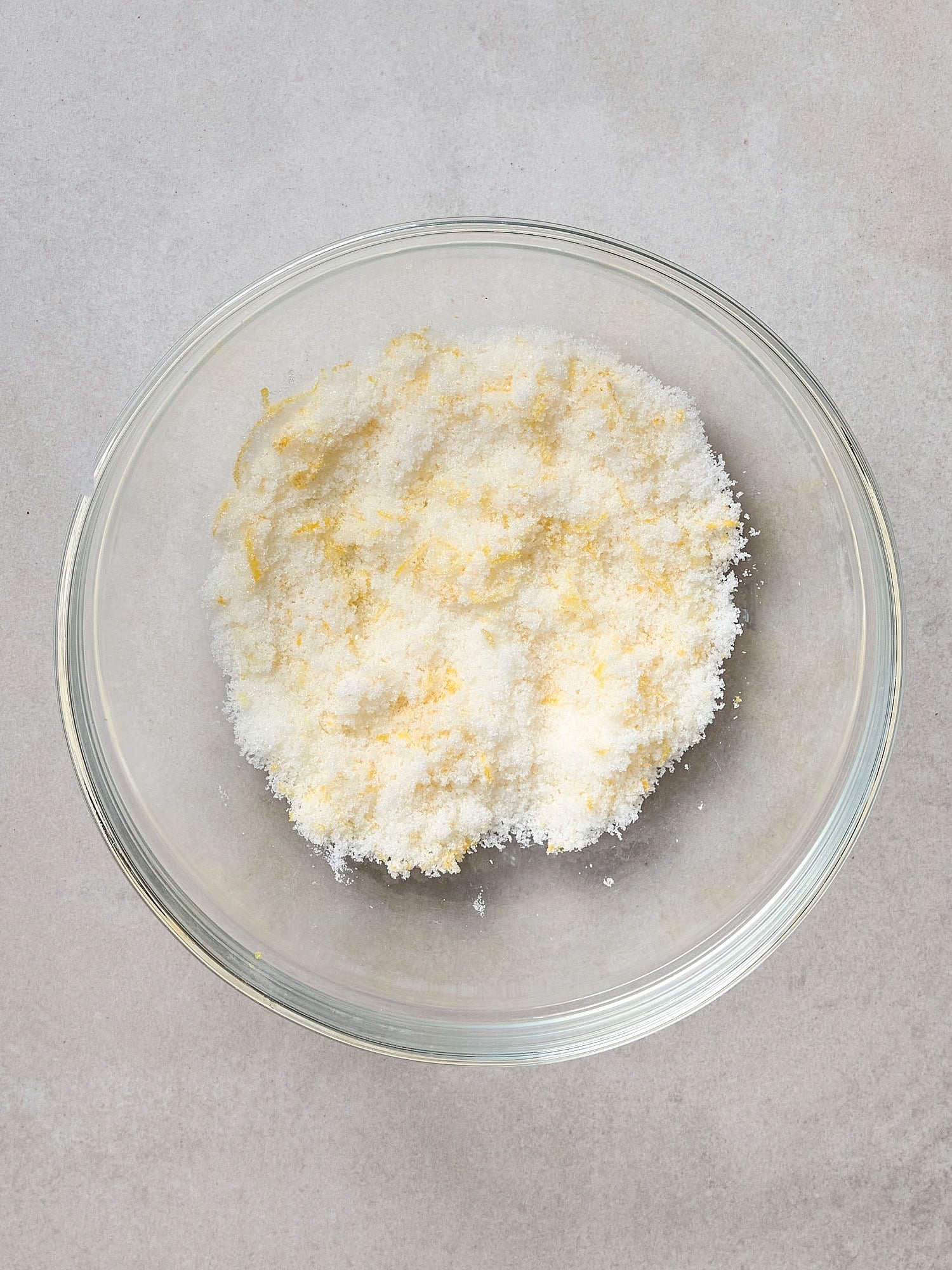 Lemon zest and sugar mixed together in bowl.