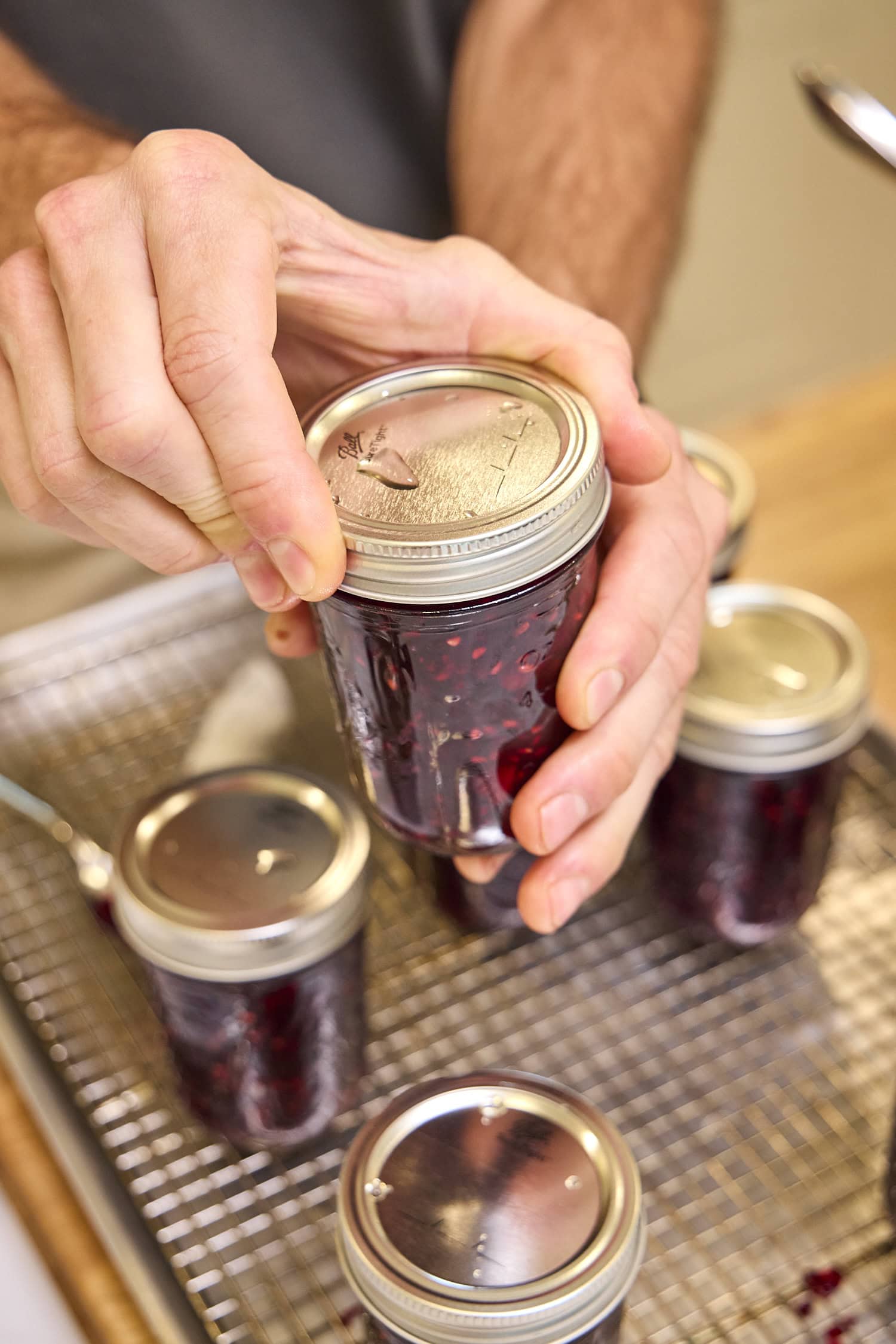 Tightening lid and ring on canning jar.