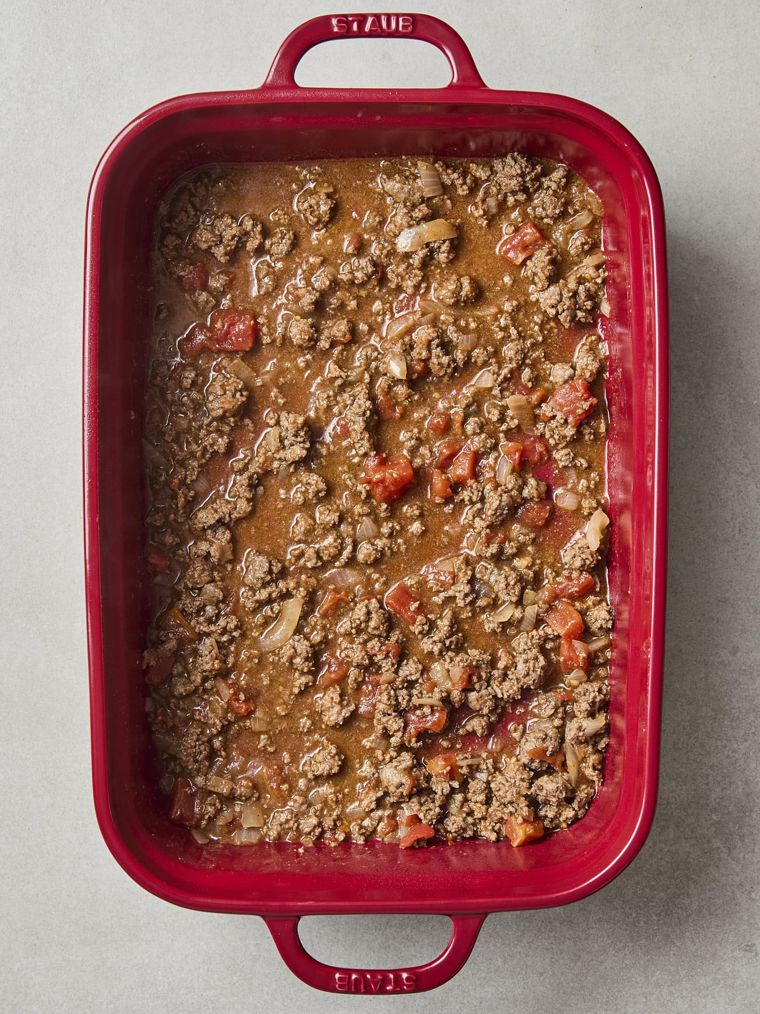 Ground beef mixture spread in layer for taco casserole.