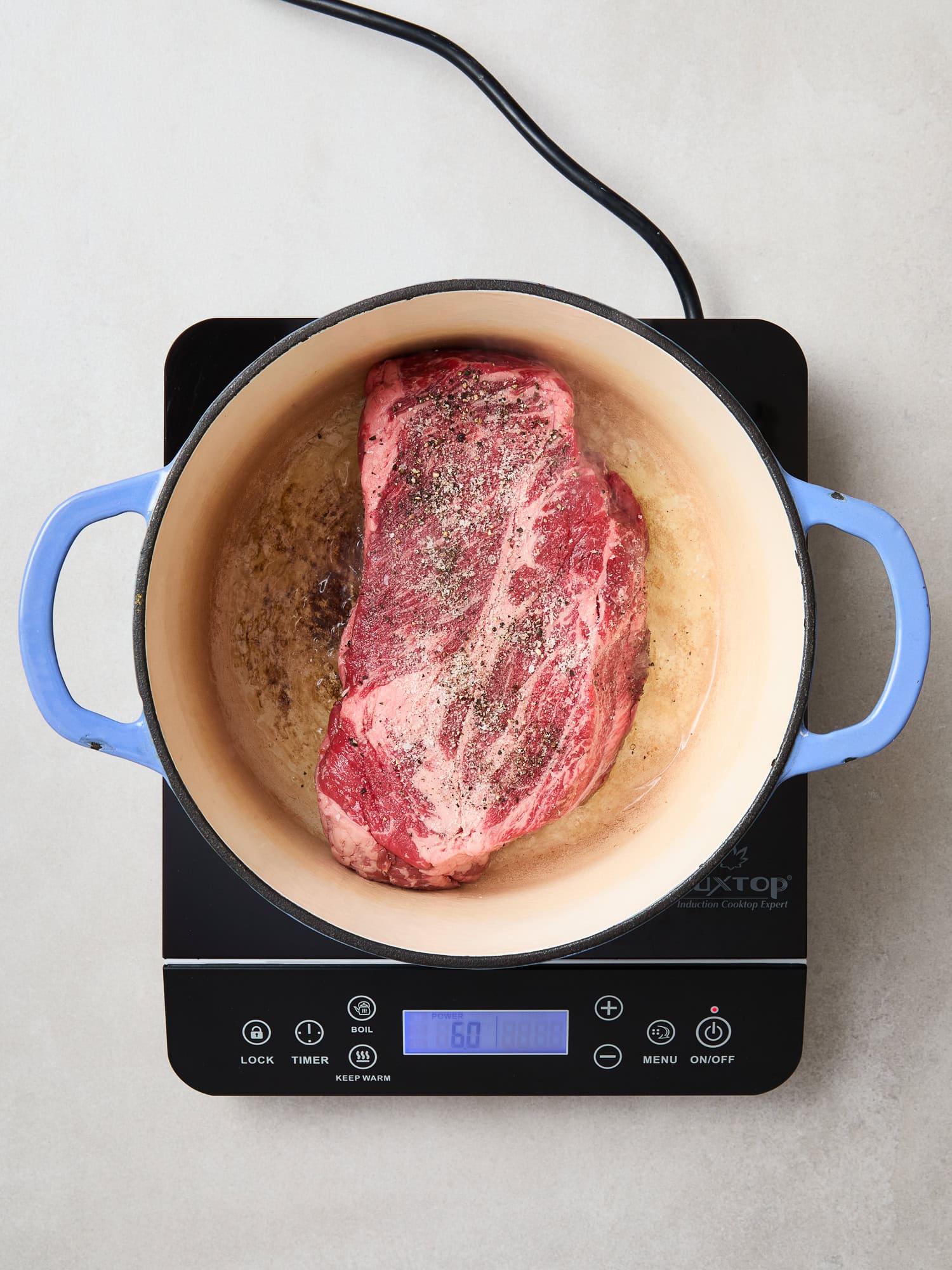 Chuck roast begins to brown in a Dutch oven.