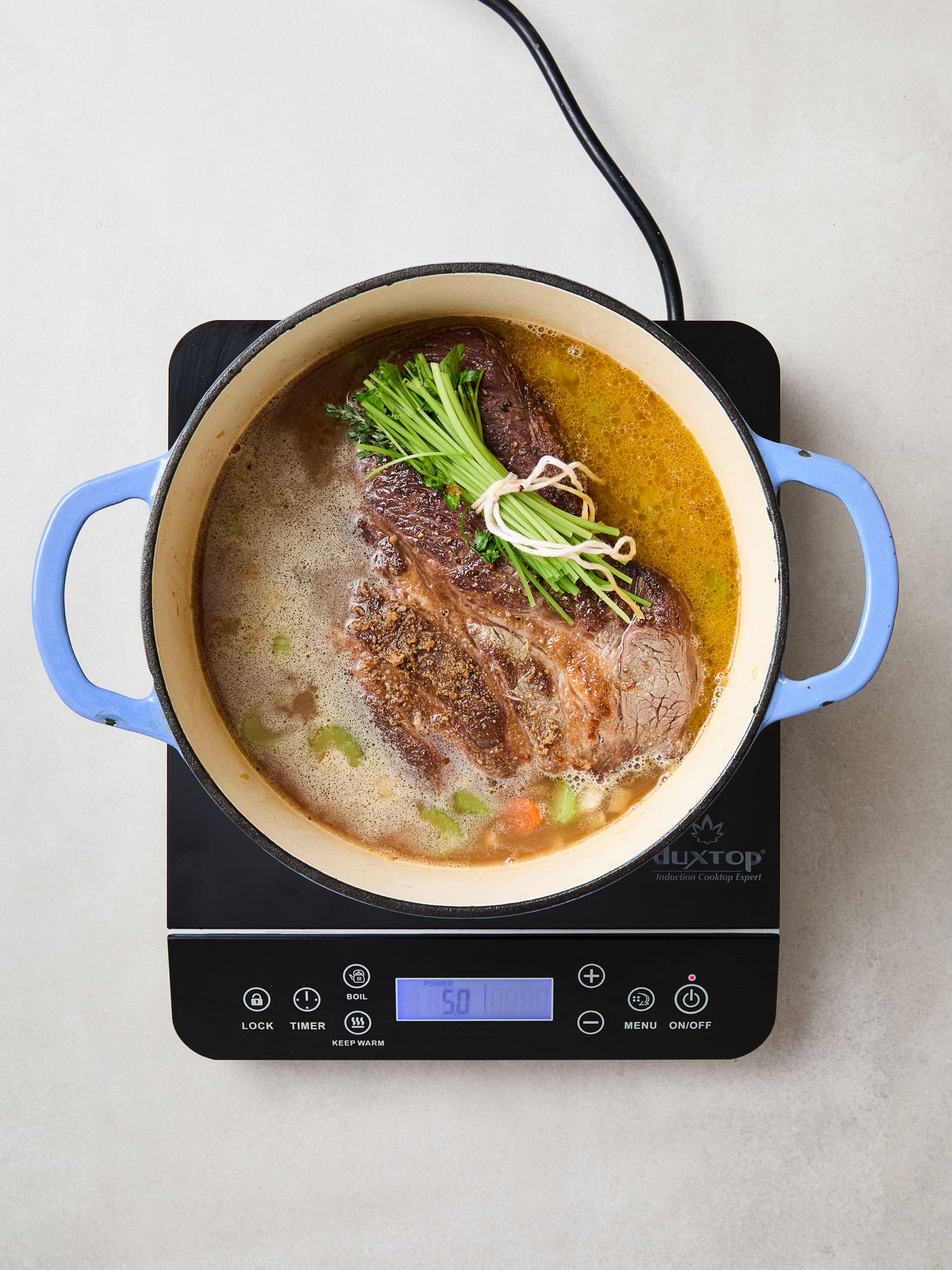 Chuck roast cooking with vegetables for beef and noodles.
