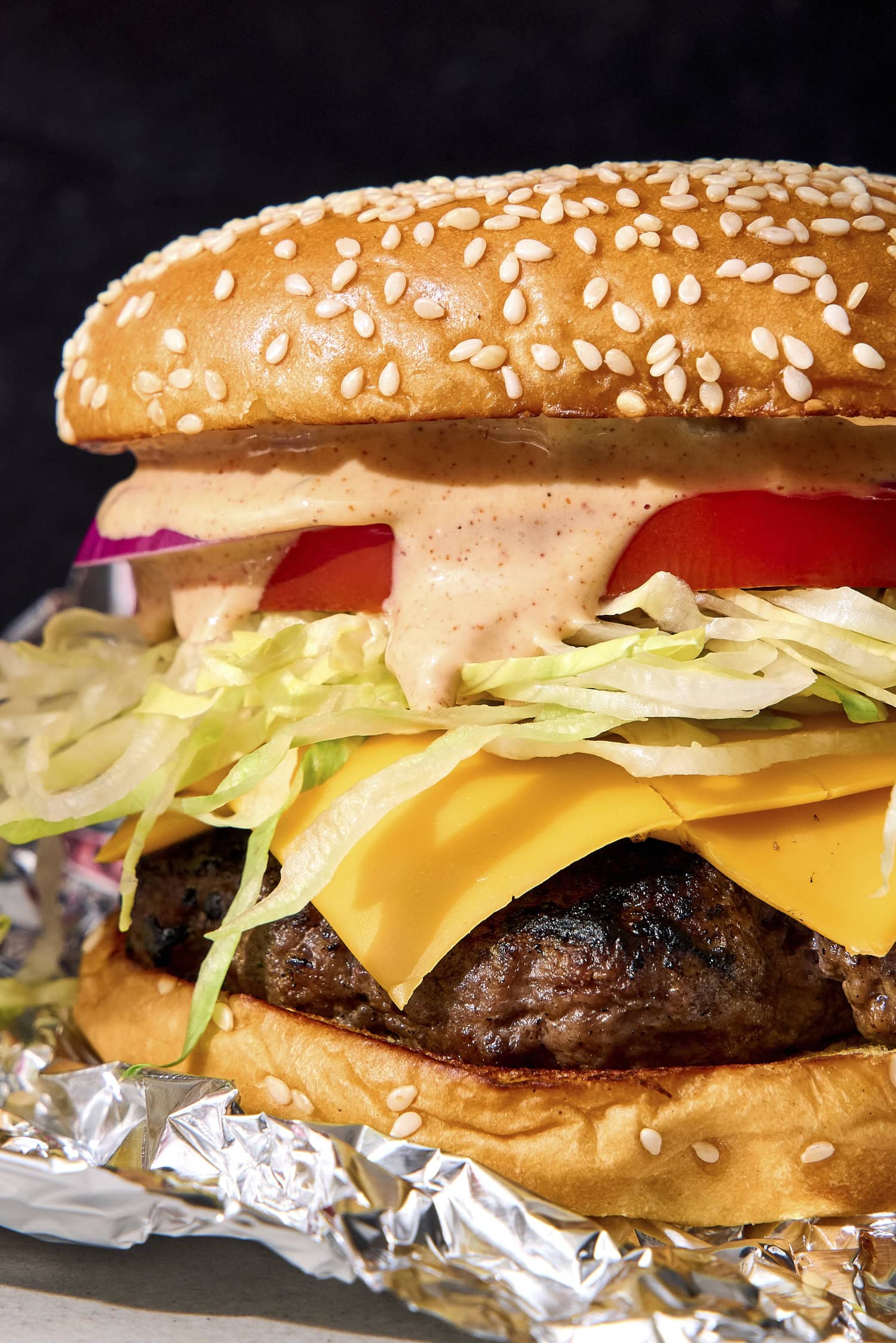 Burger sauce on a burger dripping down the side.