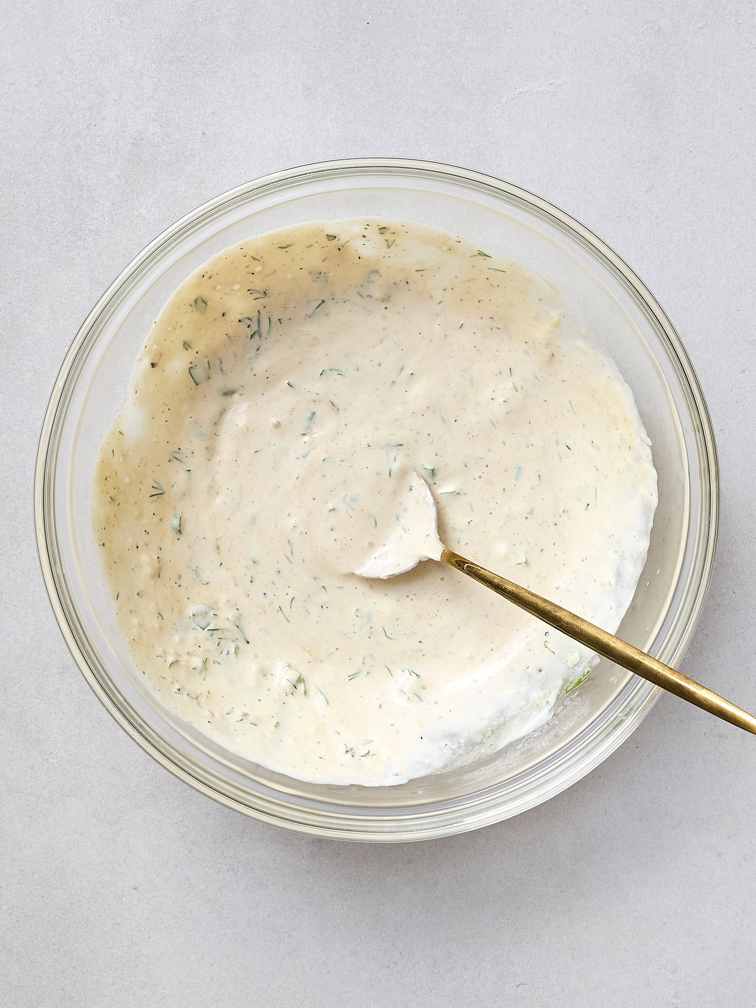Bowl with ingredients mixed together for creamy herb sauce.