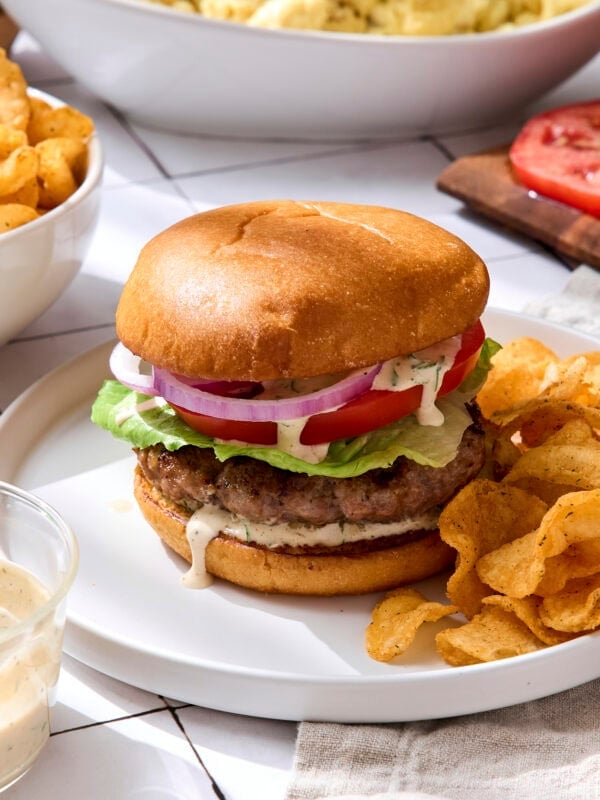 Grilled pork burgers with tomato, lettuce, onion, and homemade sauce.