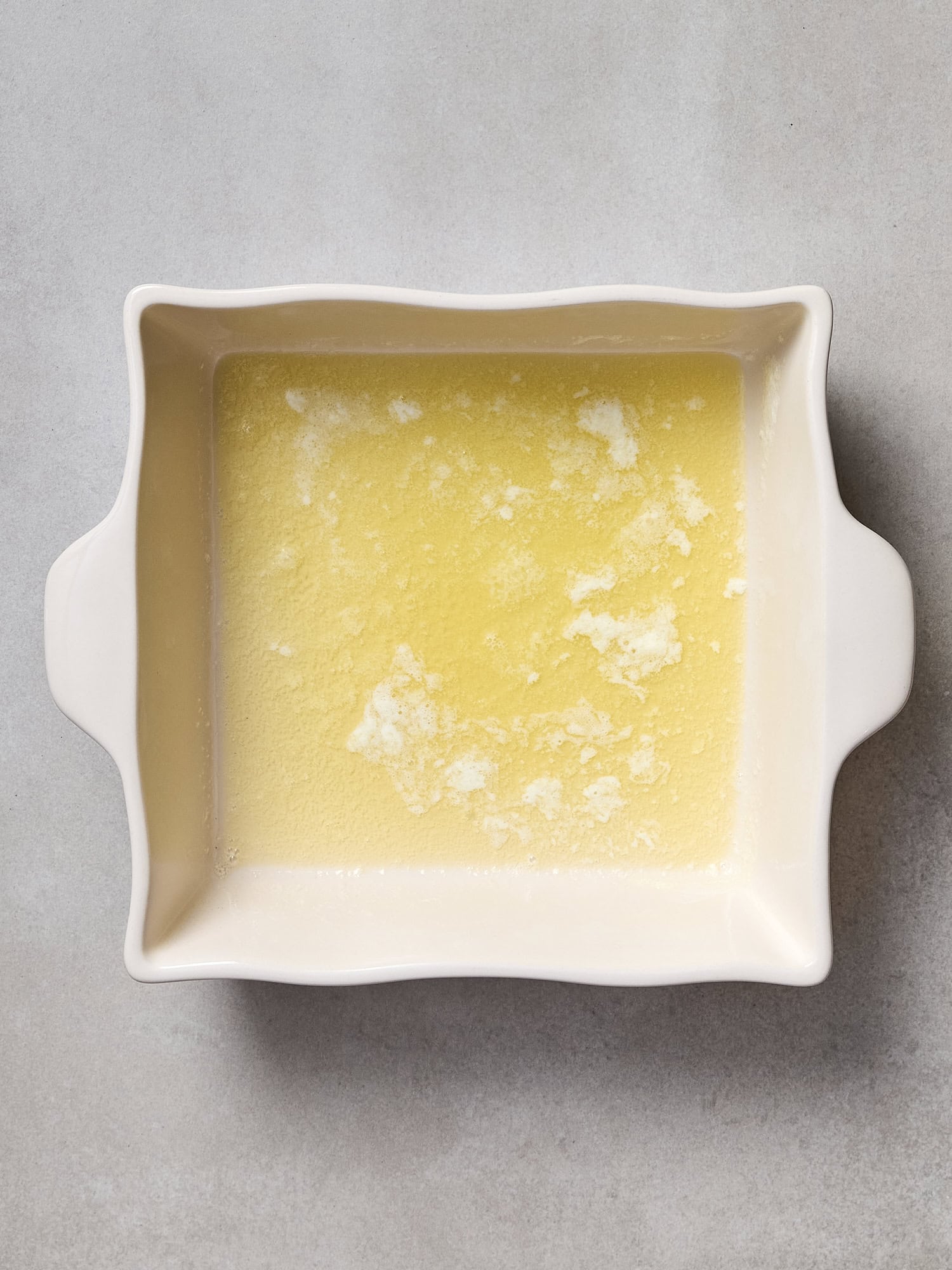 Melted butter in a baking dish.