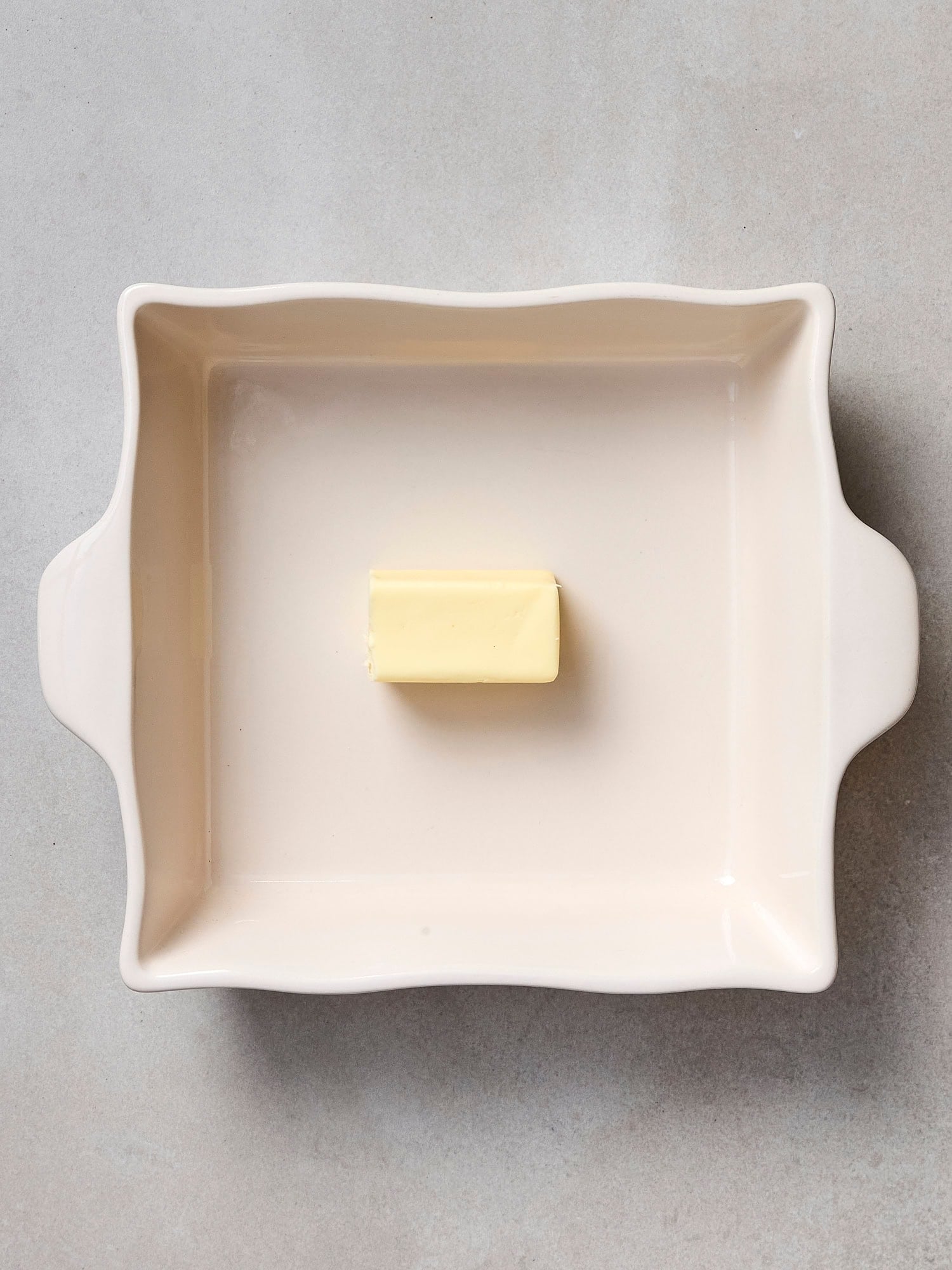 Baking dish with half stick of butter.