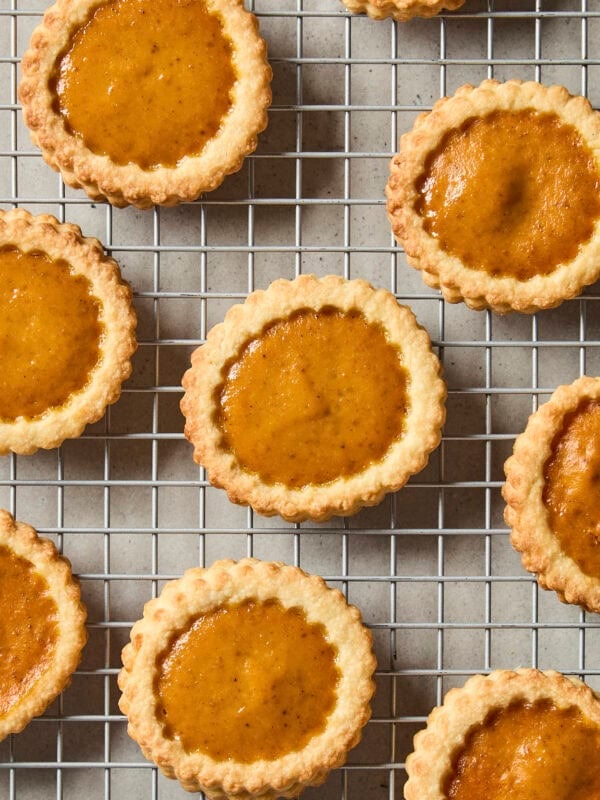 Baked small pumpkin pie cookies on cooling rack.