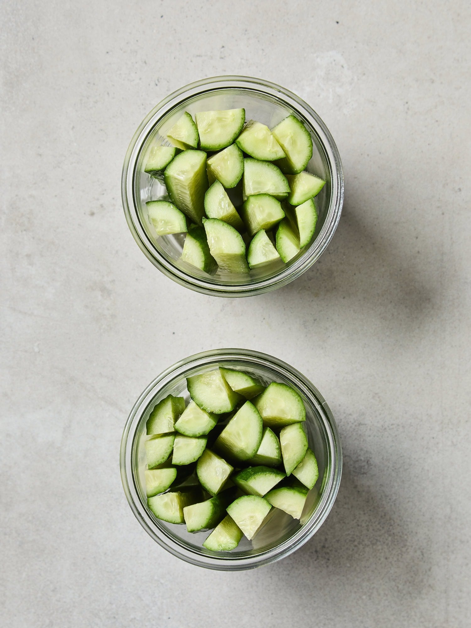 Speared cucumbers packed into glass jars prior to pickling.