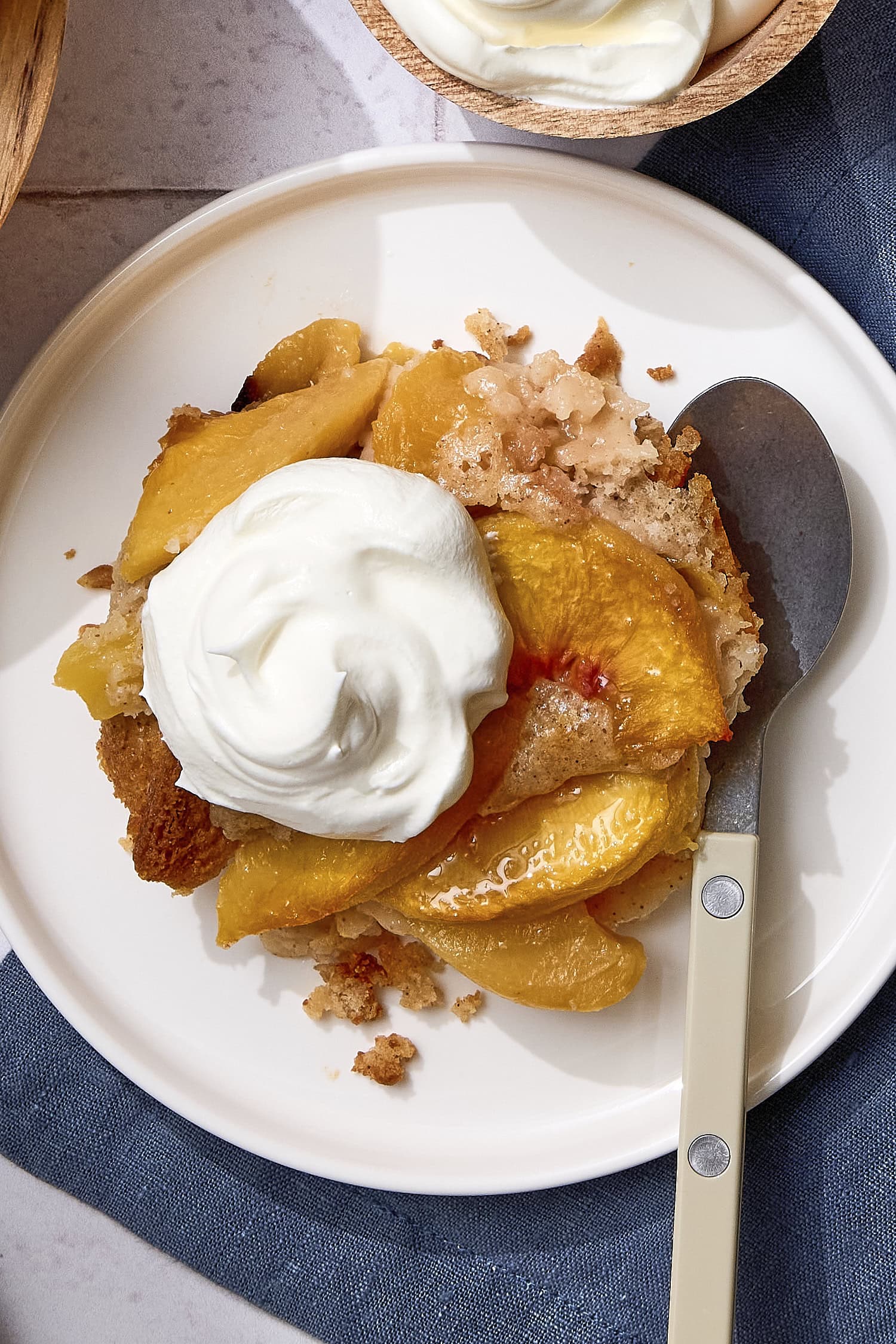 Plate with peach cobbler topped with whipped cream.