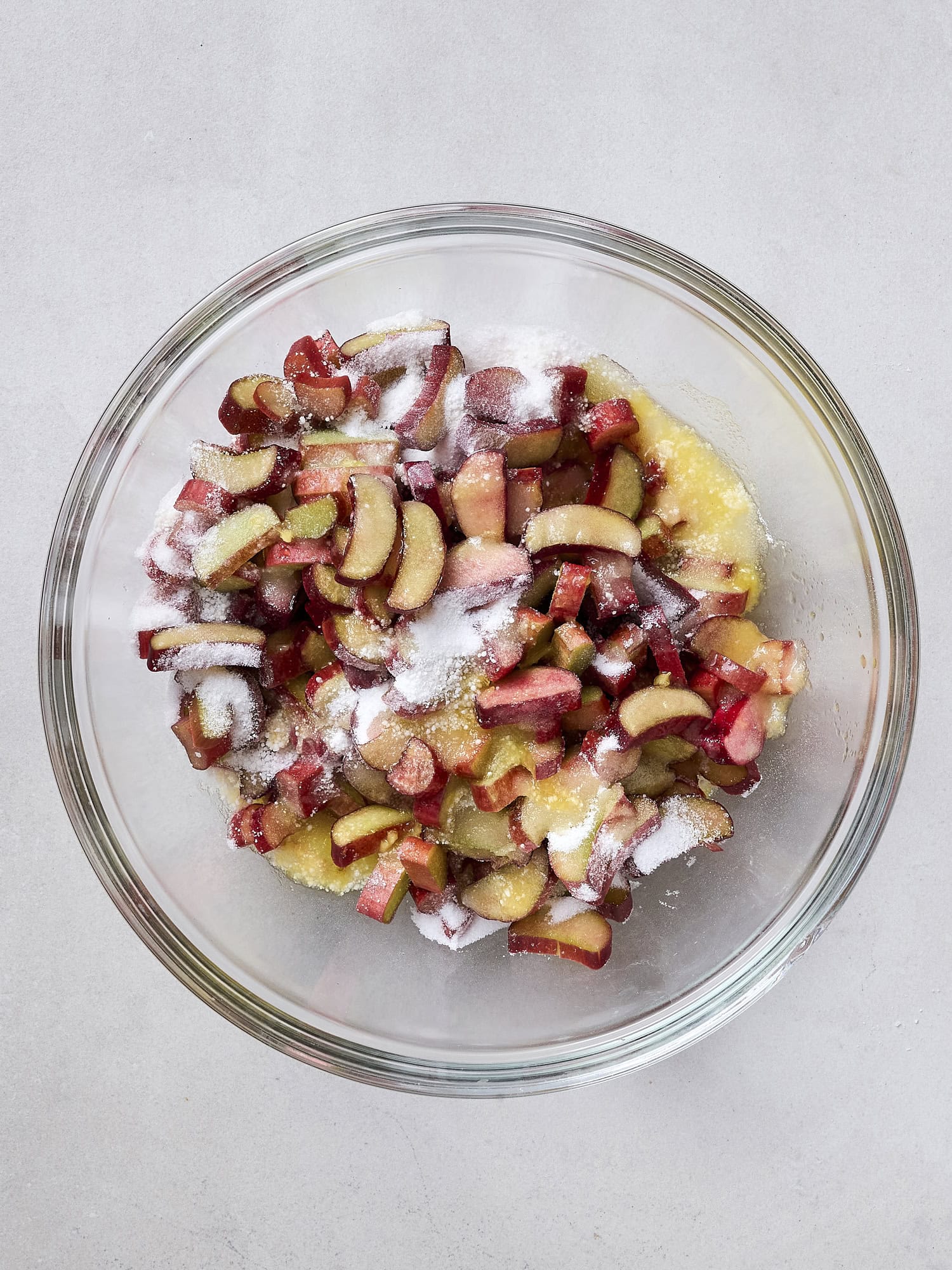 Rhubarb crisp filling mixed together in glass bowl.