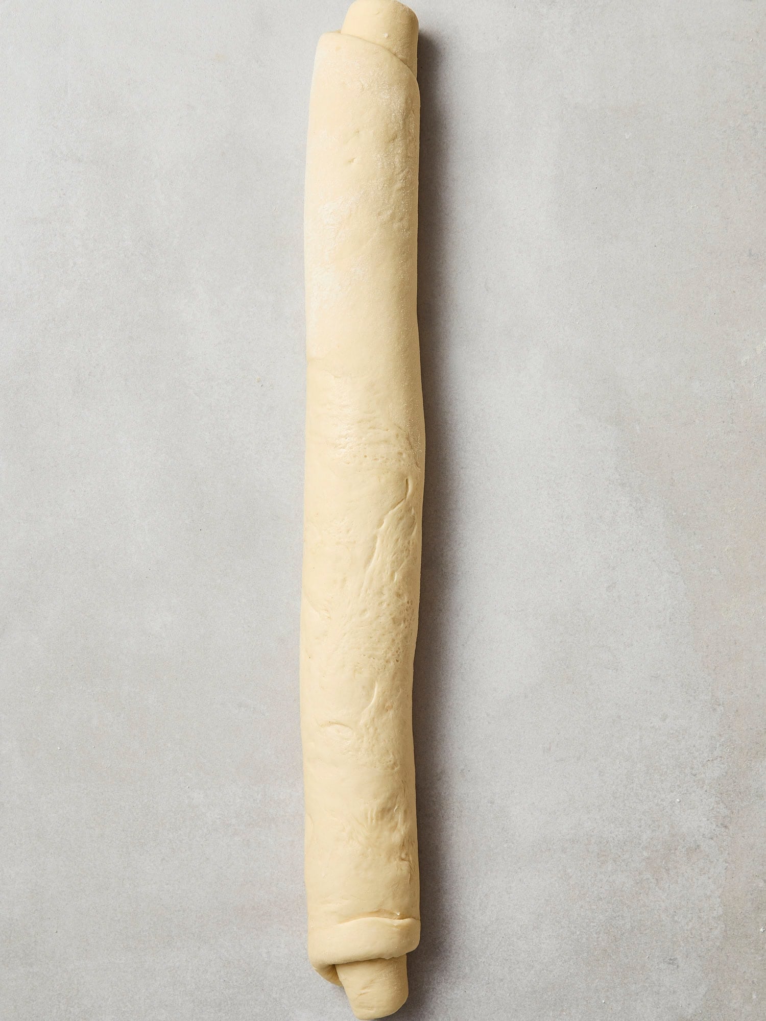 A cinnamon roll log prior to slicing.