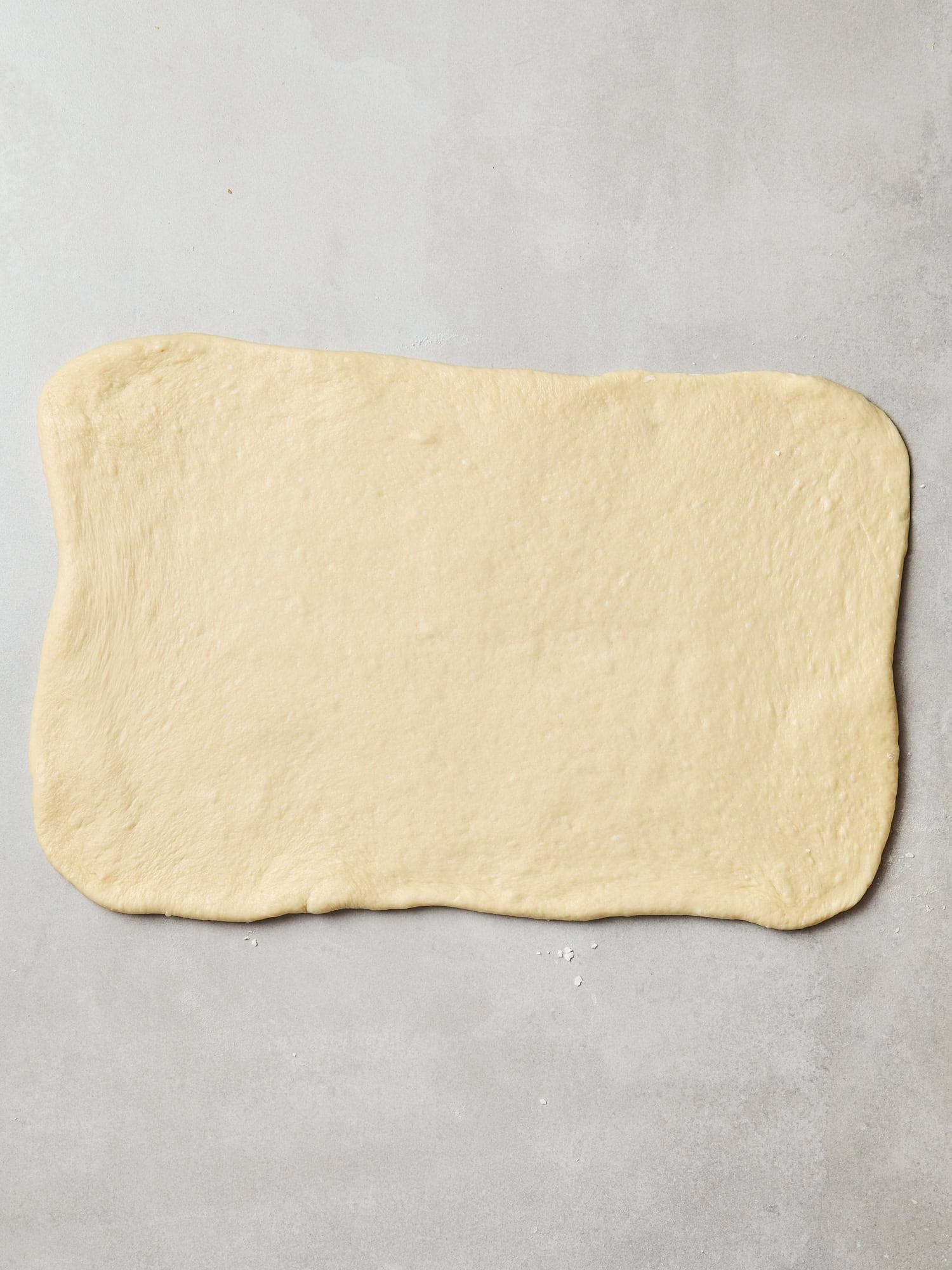 Dough rolled out into a flat rectangle to create cinnamon rolls.