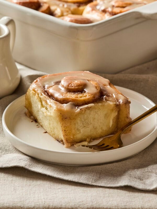 Plate with single cinnamon roll with brown butter icing.